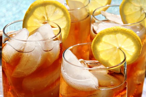 Four glasses of lemon ice tea outside by the pool.